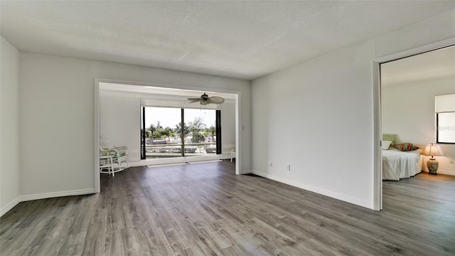 unfurnished room featuring a textured ceiling, hardwood / wood-style flooring, and ceiling fan