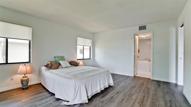 bedroom featuring hardwood / wood-style flooring and connected bathroom