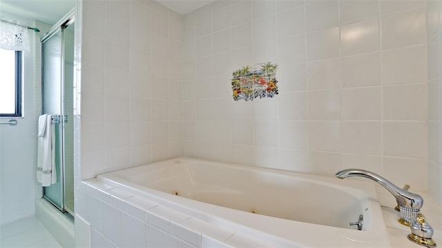 bathroom featuring a relaxing tiled tub and tile patterned floors