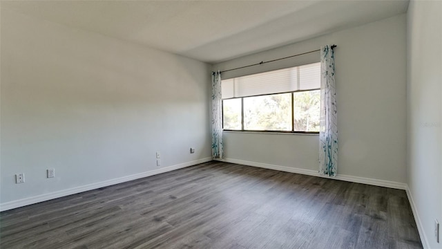 unfurnished room with dark hardwood / wood-style flooring