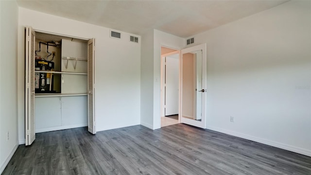 unfurnished bedroom with wood-type flooring and a closet