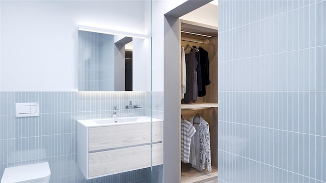 bathroom with tile walls, vanity, and toilet