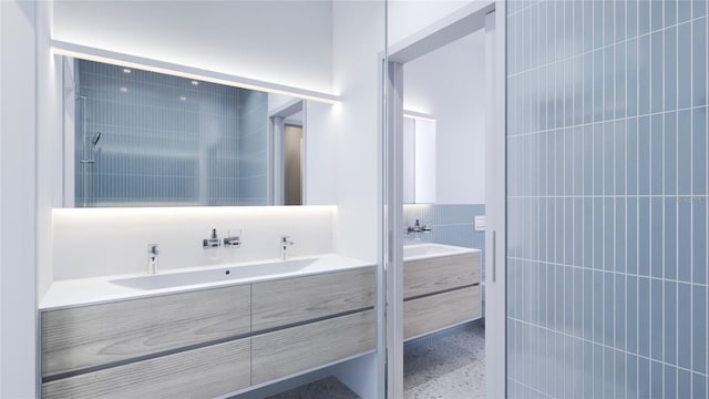 bathroom with a tile shower, tile walls, and vanity