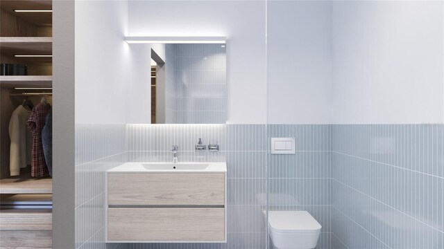 bathroom featuring tile walls, vanity, and toilet