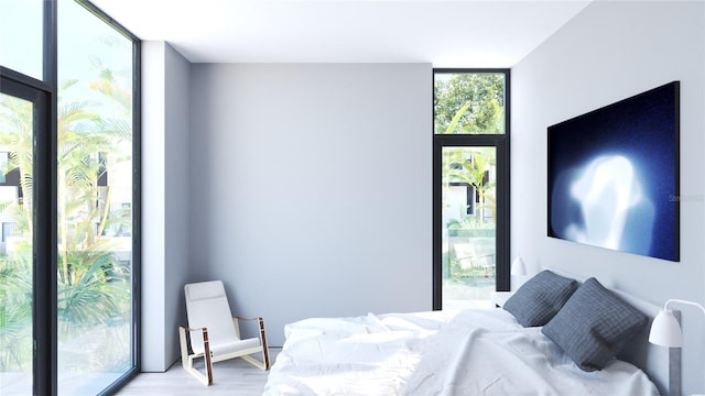 bedroom with light hardwood / wood-style floors, floor to ceiling windows, and access to exterior