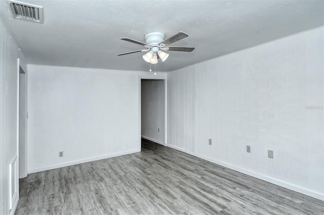 spare room featuring ceiling fan, wood-type flooring, and a textured ceiling