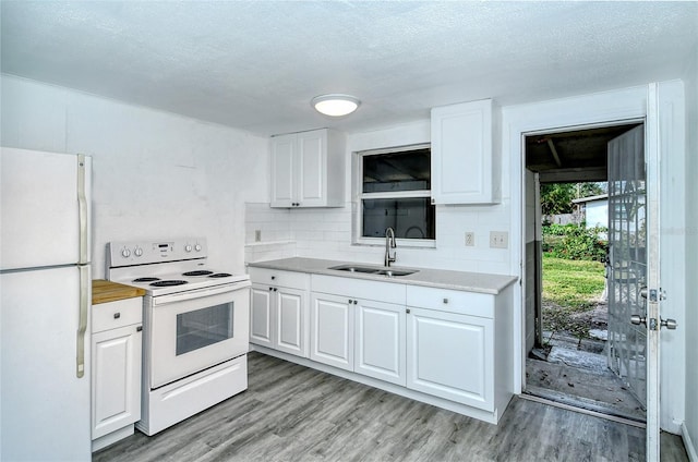 kitchen with a textured ceiling, white appliances, sink, white cabinetry, and light wood-type flooring