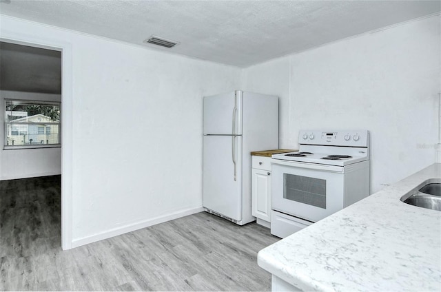 kitchen with white cabinetry, light wood-type flooring, white appliances, and a textured ceiling