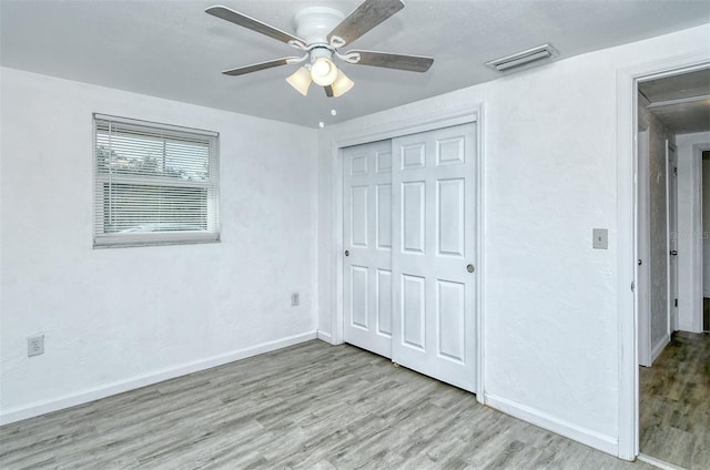 unfurnished bedroom featuring light wood-type flooring, a closet, and ceiling fan