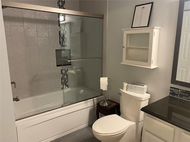 full bathroom featuring toilet, shower / bath combination with glass door, and oversized vanity