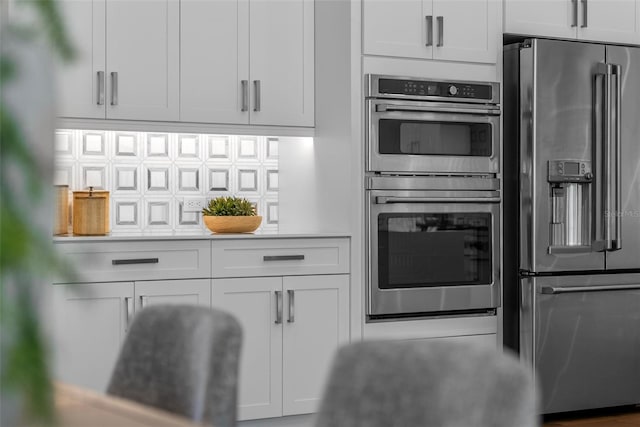 kitchen featuring white cabinetry, backsplash, and stainless steel appliances