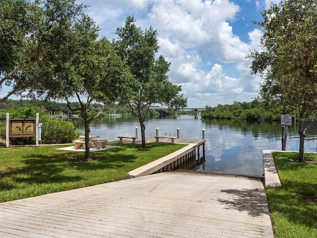 view of dock featuring a water view and a lawn