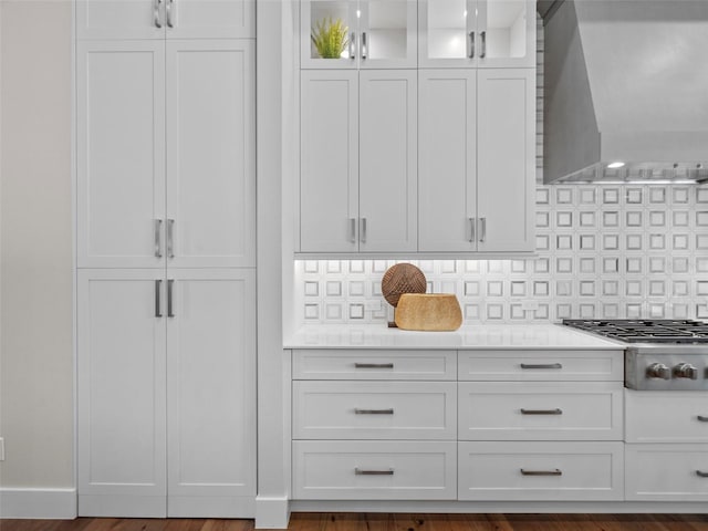 kitchen with white cabinetry, backsplash, stainless steel gas cooktop, and wall chimney exhaust hood