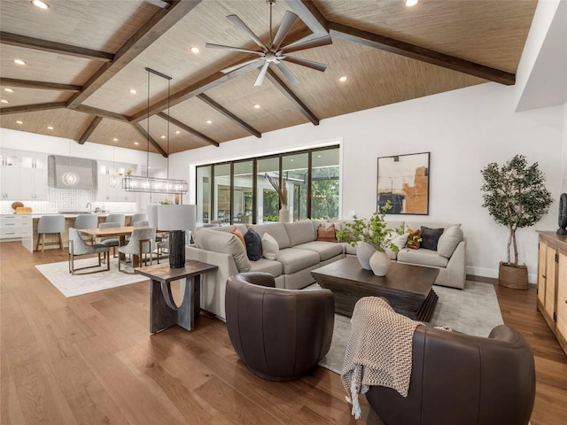 living room featuring high vaulted ceiling, beamed ceiling, ceiling fan, light hardwood / wood-style floors, and wooden ceiling