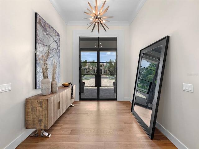 entryway featuring crown molding, french doors, and light wood-type flooring