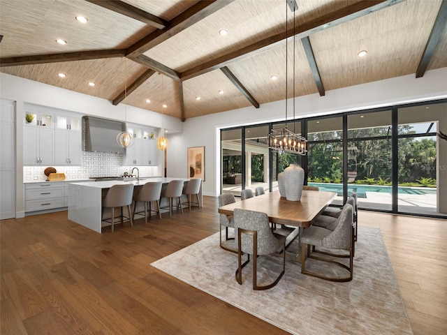 dining room featuring hardwood / wood-style flooring, sink, wood ceiling, and beamed ceiling