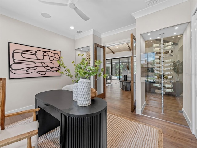 interior space with crown molding, hardwood / wood-style flooring, french doors, and ceiling fan