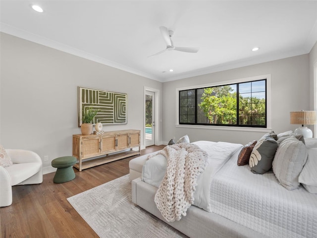 bedroom with hardwood / wood-style flooring, ornamental molding, and access to exterior