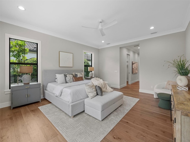 bedroom with ornamental molding, ceiling fan, and light wood-type flooring