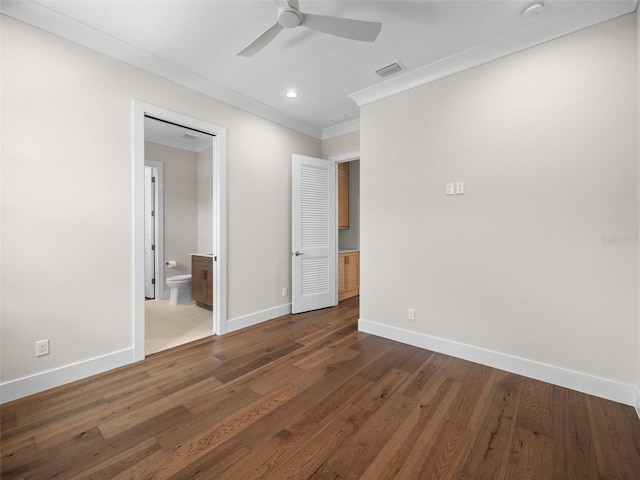 unfurnished bedroom featuring ceiling fan, ensuite bath, ornamental molding, and hardwood / wood-style floors