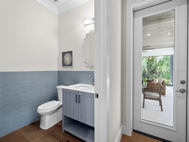 bathroom featuring vanity, wood-type flooring, tile walls, and toilet