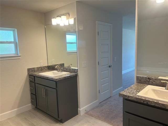 bathroom featuring a bathtub, plenty of natural light, and vanity