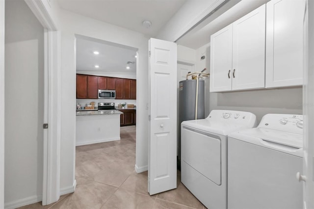 laundry room with washer and clothes dryer, light tile patterned floors, cabinets, and gas water heater