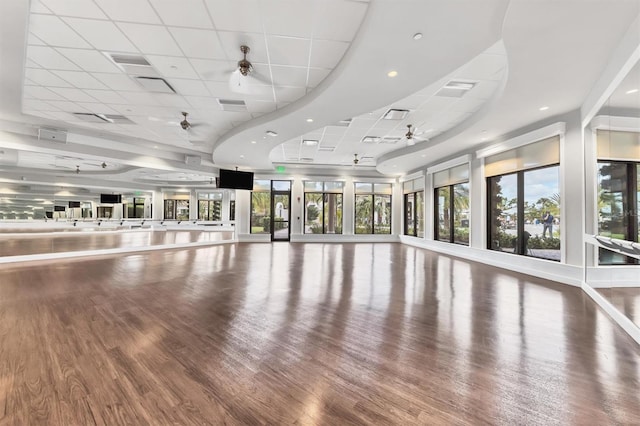 exercise area featuring a paneled ceiling, ceiling fan, and wood-type flooring