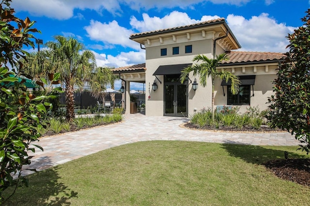 back of property featuring a lawn and french doors