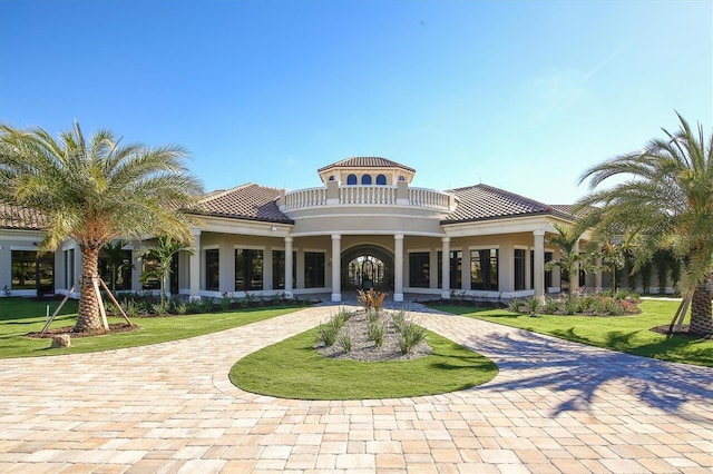 rear view of house featuring a lawn and a balcony