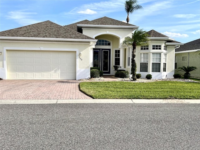 view of front of home featuring a garage, a shingled roof, decorative driveway, and stucco siding