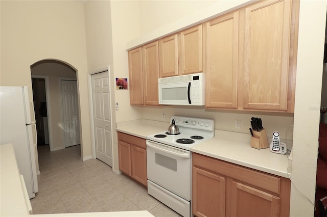 255 Royal Palm Dr, Davenport, FL 33837 - kitchen with arched walkways, white appliances, light countertops, and light brown cabinets