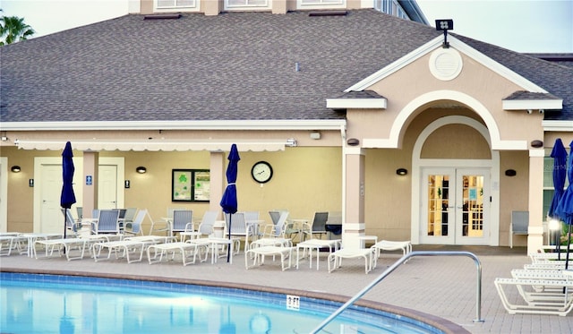 255 Royal Palm Dr, Davenport, FL 33837 - exterior space featuring french doors, a patio, stucco siding, a shingled roof, and a community pool