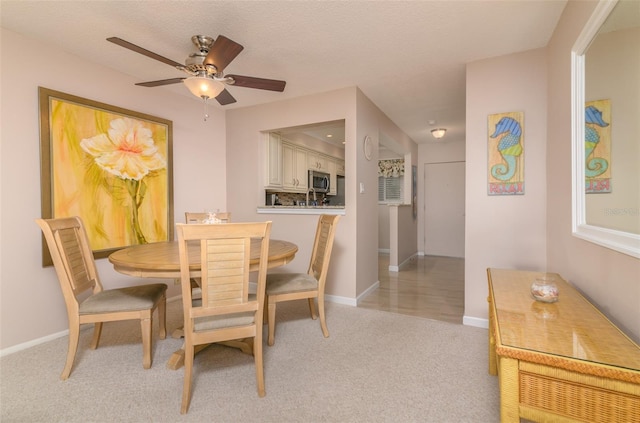 carpeted dining space with ceiling fan and a textured ceiling