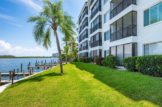 dock area featuring a balcony, a lawn, and a water view