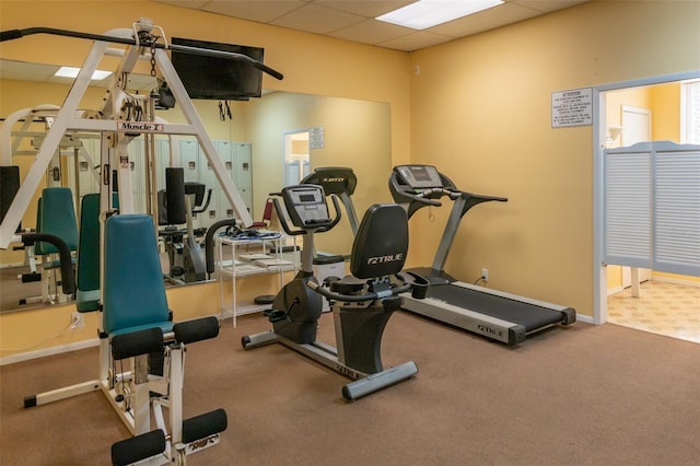 exercise room with carpet and a paneled ceiling