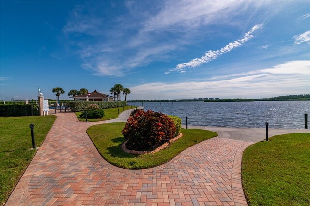 view of home's community featuring a water view and a lawn