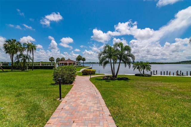 view of property's community with a lawn and a water view