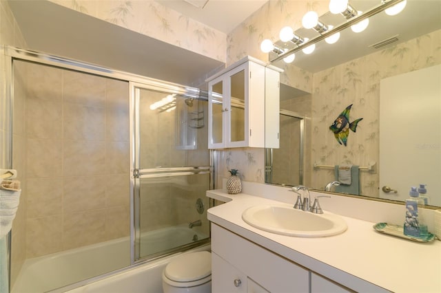 full bathroom with toilet, oversized vanity, and bath / shower combo with glass door