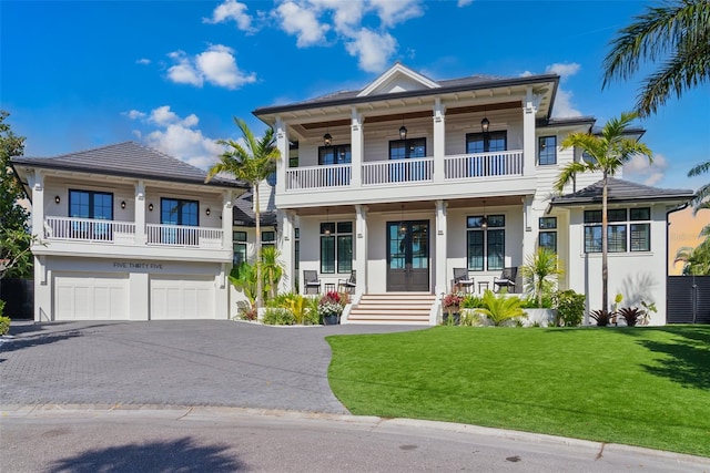 view of front of house with a porch, a garage, and a front lawn