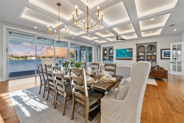 dining room featuring built in shelves, light wood-type flooring, a notable chandelier, and coffered ceiling