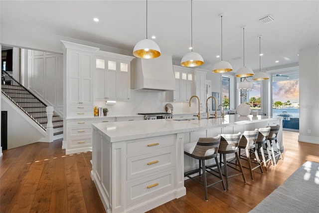 kitchen featuring white cabinets, decorative light fixtures, and a spacious island