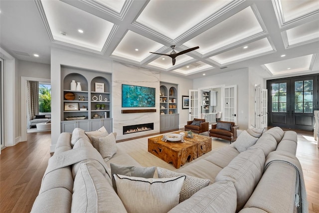 living room with hardwood / wood-style floors, built in features, and a wealth of natural light