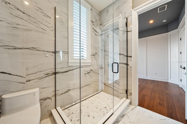 bathroom with hardwood / wood-style floors, toilet, and walk in shower