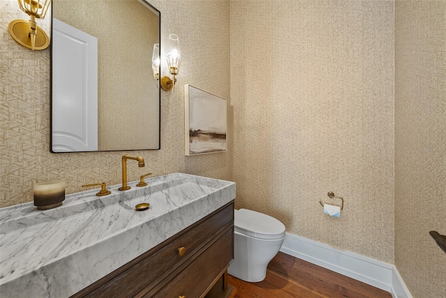 bathroom with hardwood / wood-style floors, vanity, and toilet