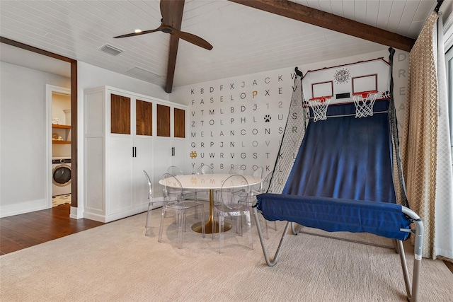 dining area featuring lofted ceiling with beams, ceiling fan, wood-type flooring, and washer / dryer