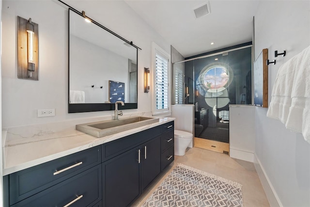 bathroom featuring tile patterned floors, a shower with door, vanity, and toilet