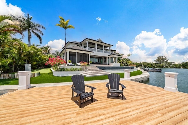 view of dock with a water view and a lawn