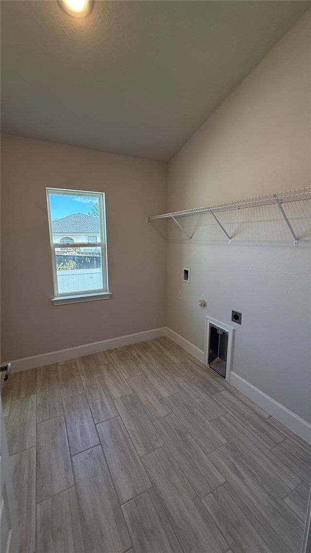 washroom with electric dryer hookup, gas dryer hookup, hookup for a washing machine, and light hardwood / wood-style flooring