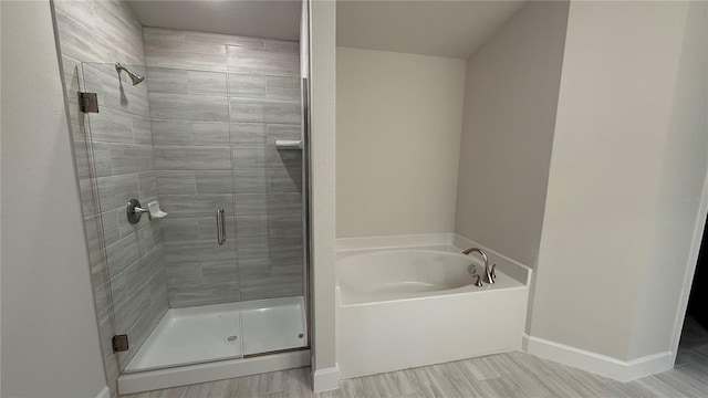 bathroom with wood-type flooring and plus walk in shower